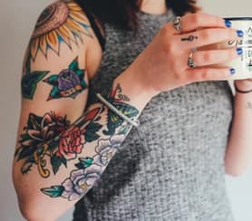 Arm with old school flower and sunflower tattoos