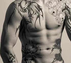 Torso with black tattoos: tribal, roses and skulls